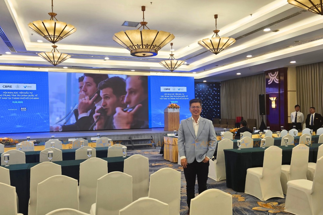Interpreter Khang Nguyen at a microfinance event auditorium.