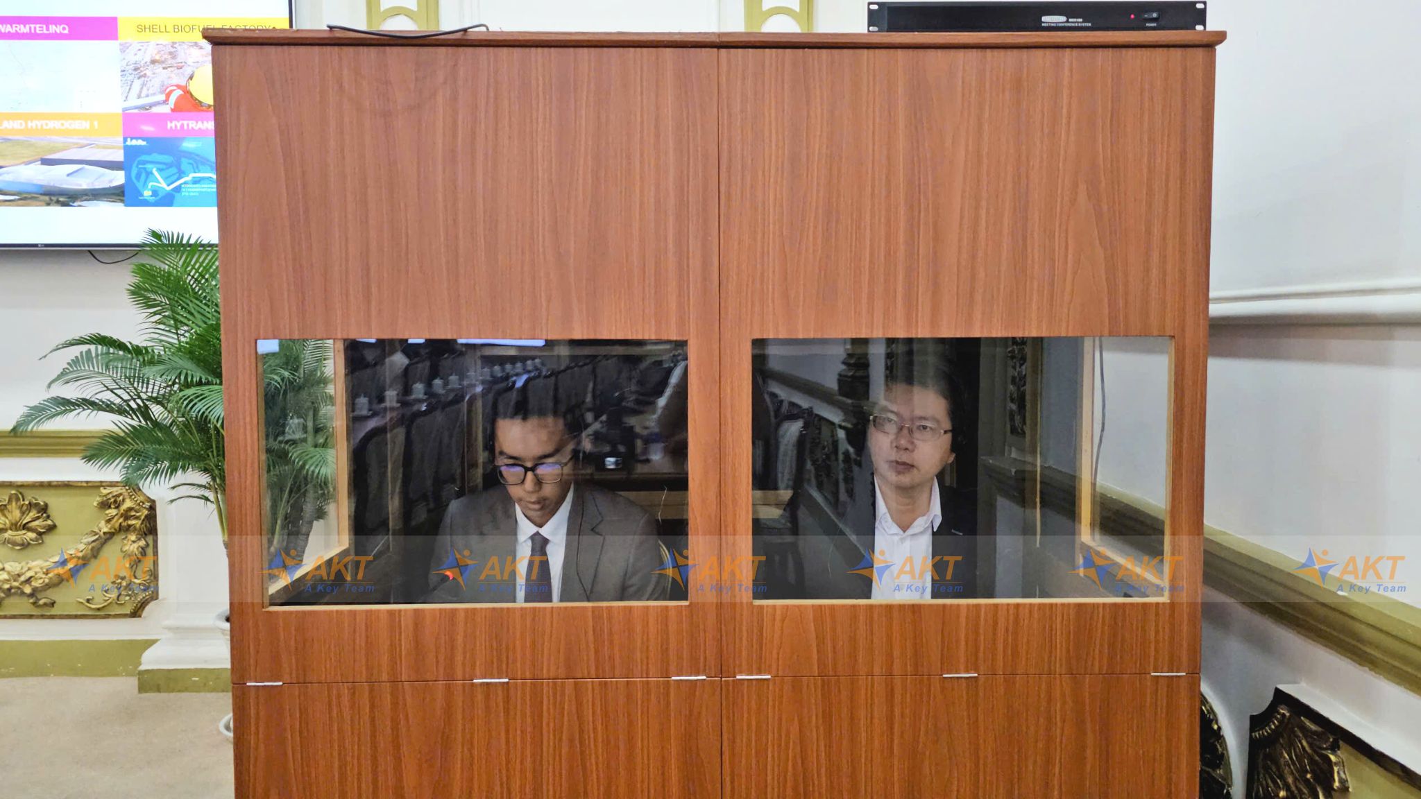 Interpreter Khang Nguyen providing simultaneous interpretation (cabin interpretation) inside a standard soundproof booth at a high-level international conference.